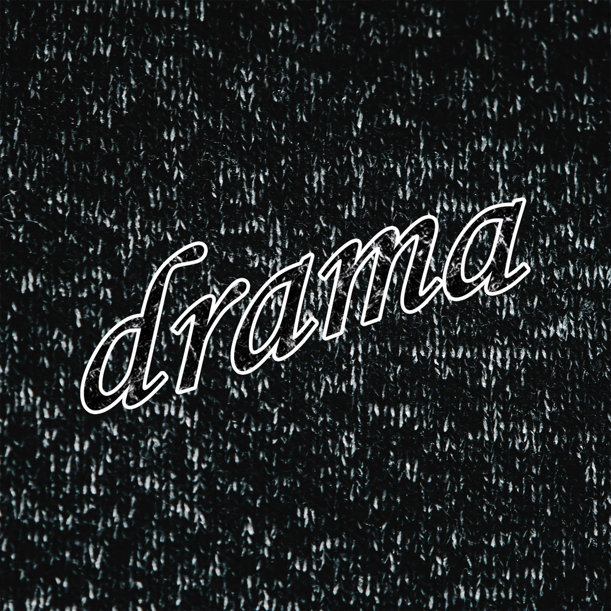A close-up of a black heathered fabric surface with the word "drama" written across it in white outlined script.